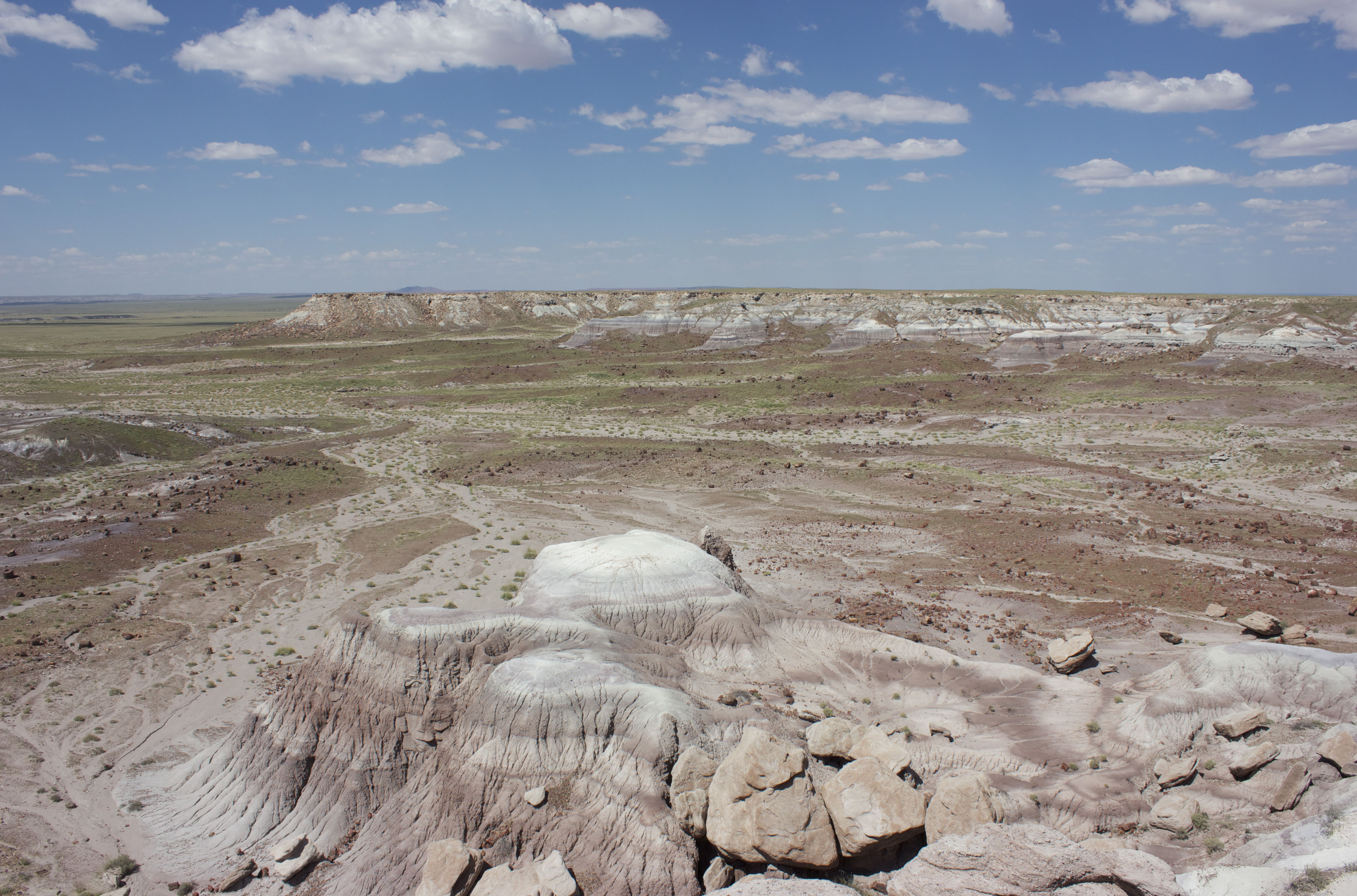 Painted Desert landscape with a cloud-dotted blue sky.