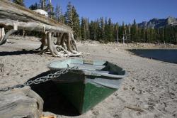 A green rowboat chained on the shore at Horseshoe Lake. 